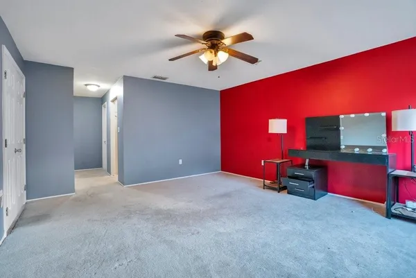 a view of an empty room with projector and fan