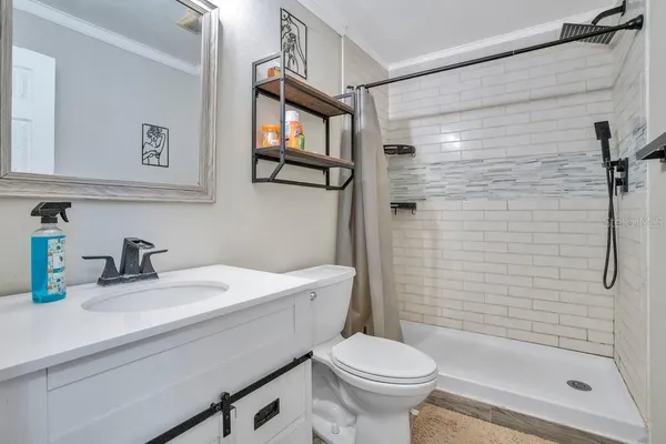 a bathroom with a sink a toilet and shower