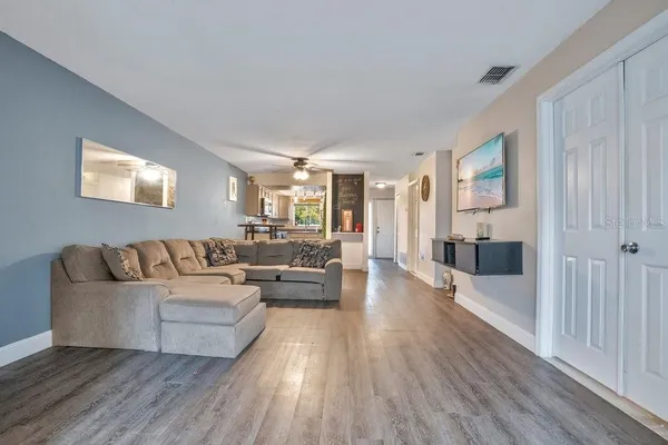 a living room with furniture and a wooden floor