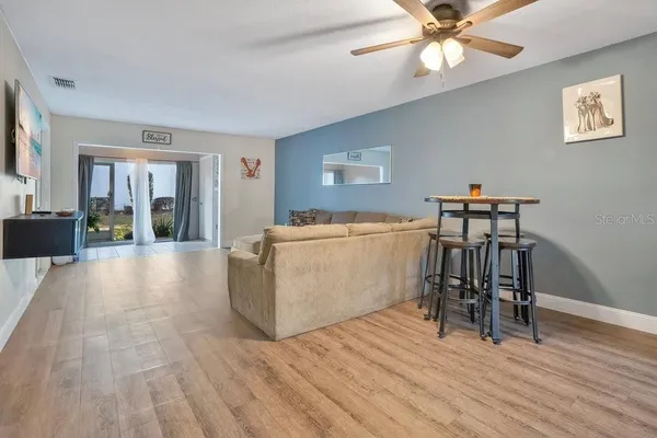 a view of a livingroom with furniture wooden floor and a ceiling fan
