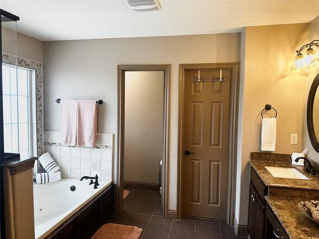 a bathroom with a tub sink and mirror
