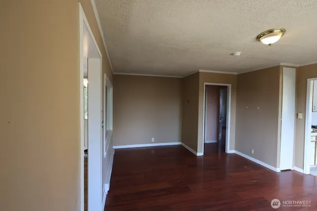 a view of an empty room with wooden floor
