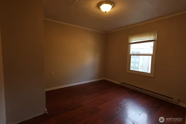 a view of a room with wooden floor and windows