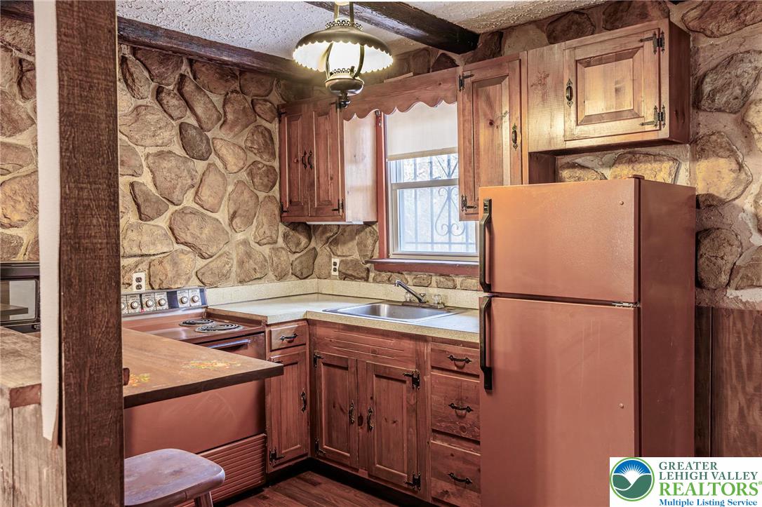 5211 Fir Lane Pocono Summit, PA 18346 - Photo 11 of 38 a kitchen with stainless steel appliances granite countertop a refrigerator a sink and white cabinets
