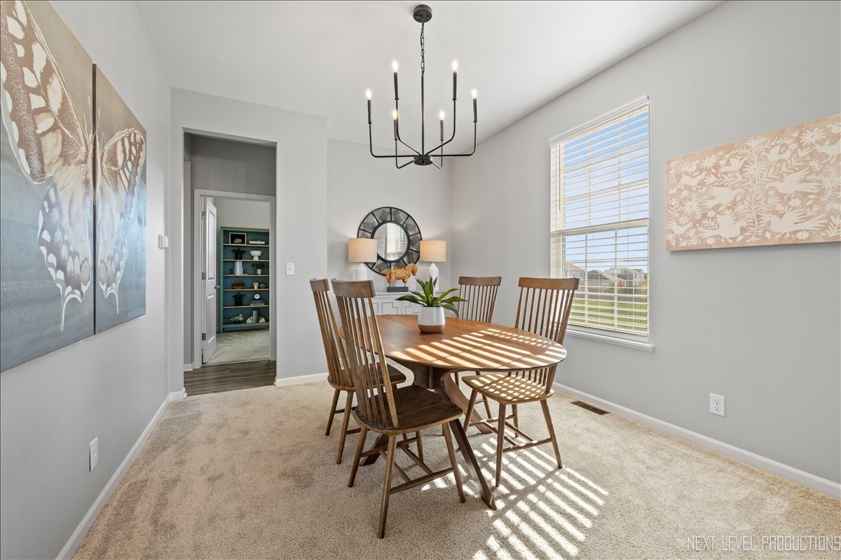 2236 Fairfax Way Yorkville, IL 60560 - Photo 6 of 28 a view of a dining room with furniture a chandelier and wooden floor