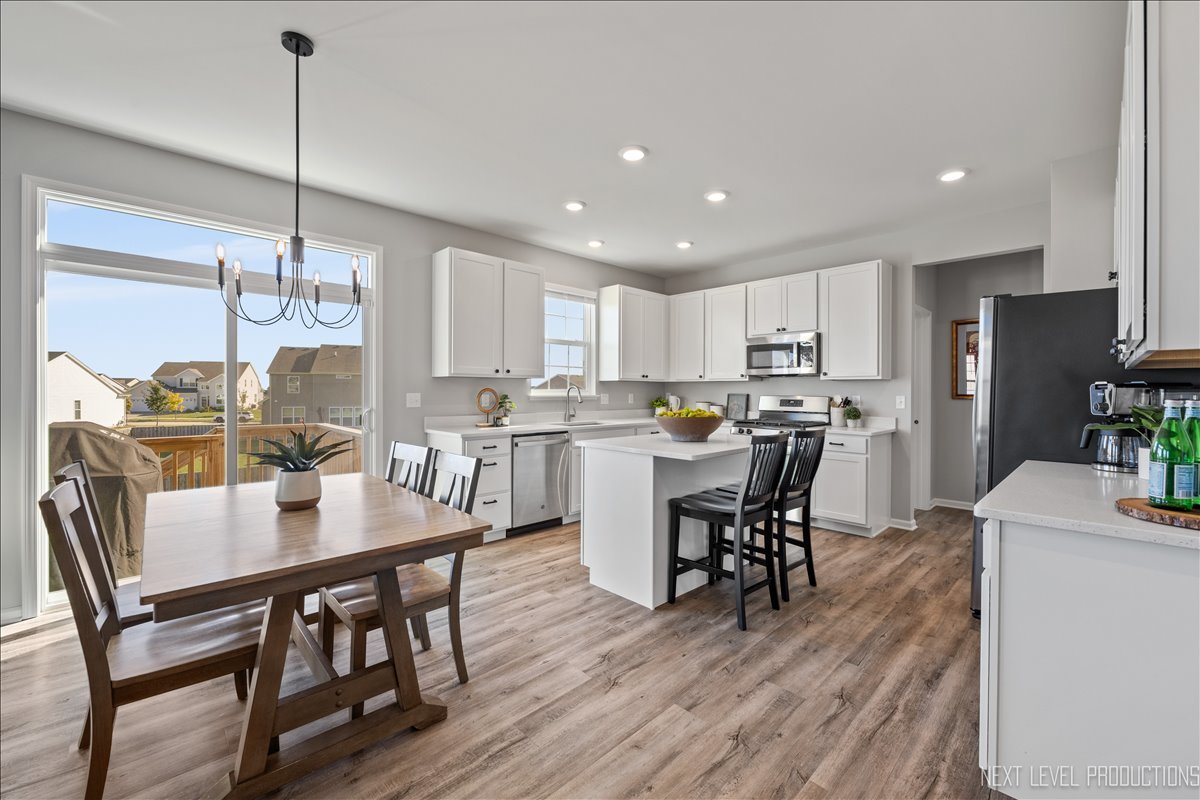 2236 Fairfax Way Yorkville, IL 60560 - Photo 8 of 28 a kitchen with kitchen island a dining table chairs stainless steel appliances and cabinets