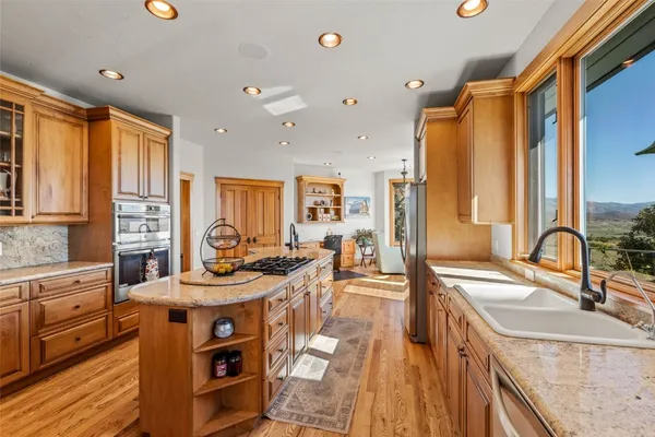 a kitchen with stainless steel appliances granite countertop a sink stove and cabinets