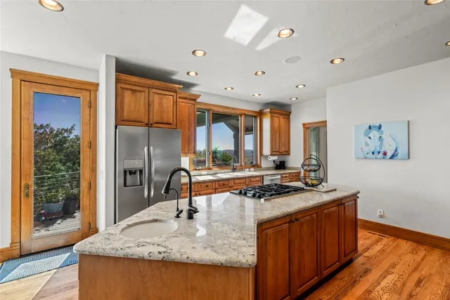 a kitchen with stainless steel appliances granite countertop a sink stove and refrigerator