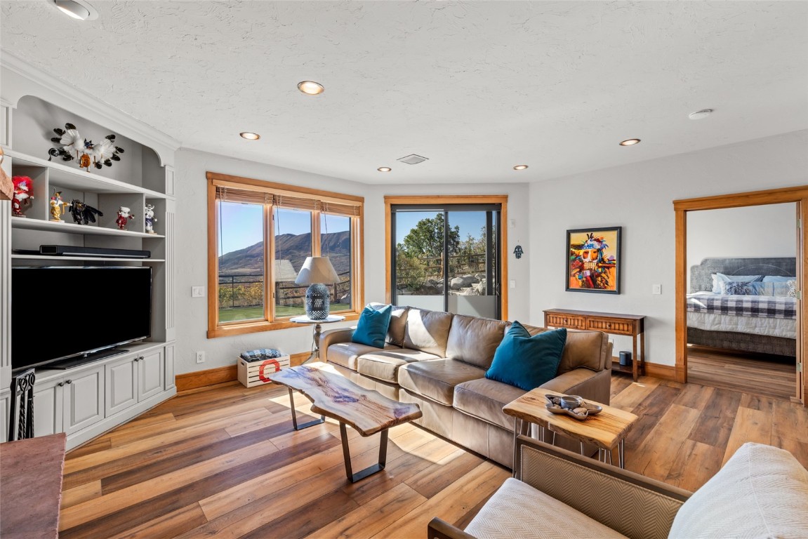 44300 Diamondback Way Steamboat Springs, CO 80487 - Photo 27 of 49 a living room with furniture a flat screen tv and a floor to ceiling window