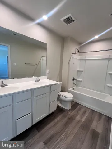 a bathroom with a double vanity sink toilet mirror and bathtub