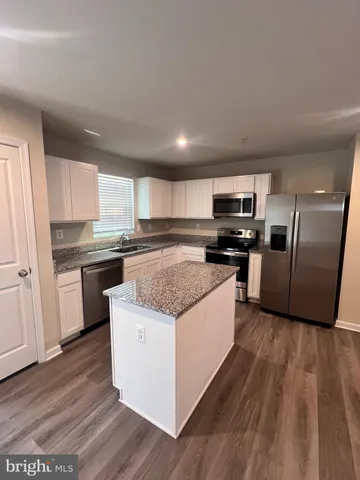 a large kitchen with stainless steel appliances granite countertop a stove a sink and a refrigerator