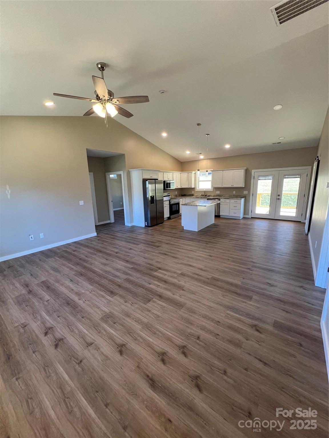 130 Peyton Elaine Road Clyde, NC 28721 - Photo 7 of 12 a view of an empty room with wooden floor and a ceiling fan