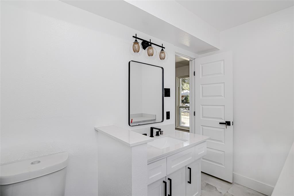 7992 Fallmeadow Lane Dallas, TX 75248 - Photo 18 of 30 a bathroom with a sink a mirror and vanity