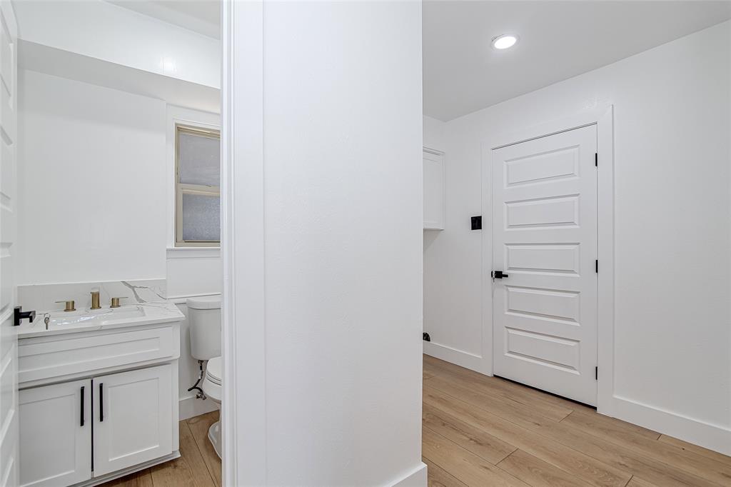 7992 Fallmeadow Lane Dallas, TX 75248 - Photo 26 of 30 a bathroom with a sink vanity and a toilet
