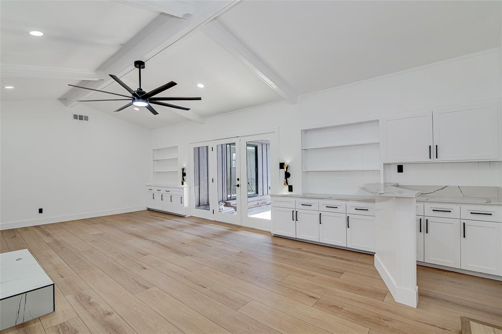 7992 Fallmeadow Lane Dallas, TX 75248 - Photo 7 of 30 a view of a kitchen with wooden floor and a ceiling fan