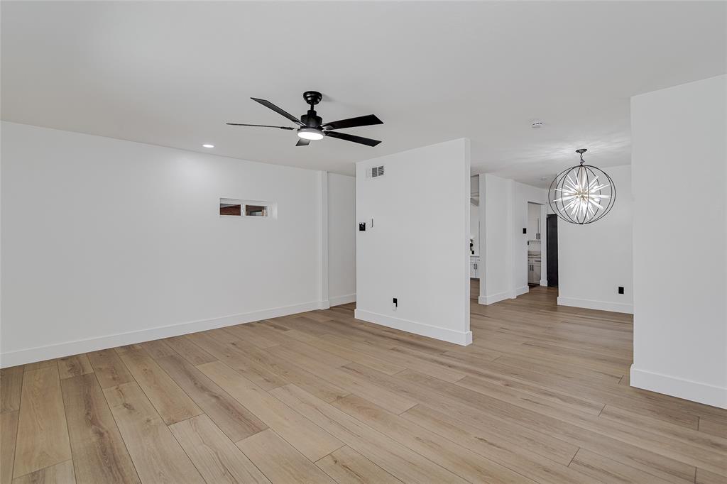 7992 Fallmeadow Lane Dallas, TX 75248 - Photo 9 of 30 an empty room with wooden floor and ceiling fan