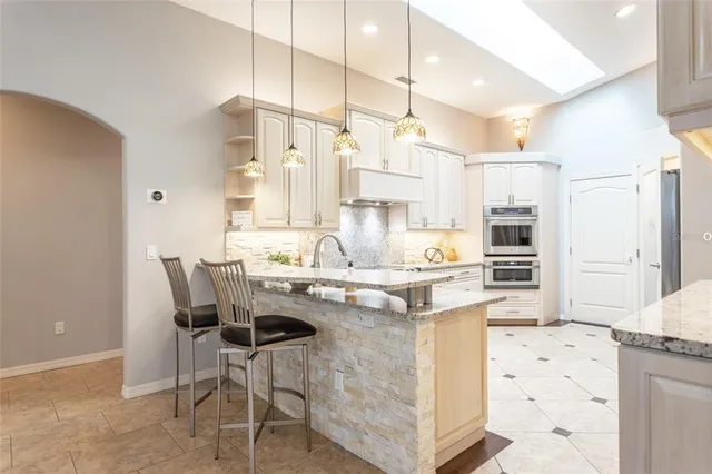 a kitchen with granite countertop white cabinets and stainless steel appliances