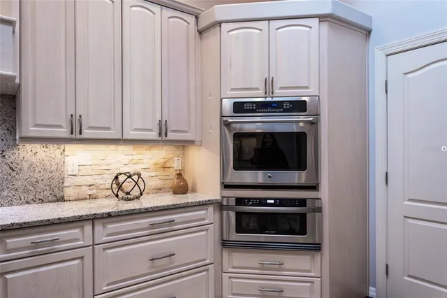 a metallic refrigerator freezer sitting in a kitchen