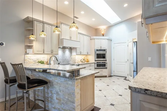 a kitchen with granite countertop a sink cabinets stainless steel appliances and dining table