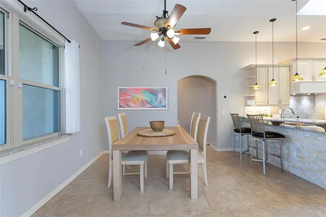 a dining room with furniture a rug a fireplace and a chandelier