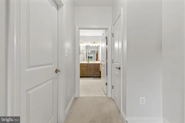 a view of a hallway with wooden floor and kitchen