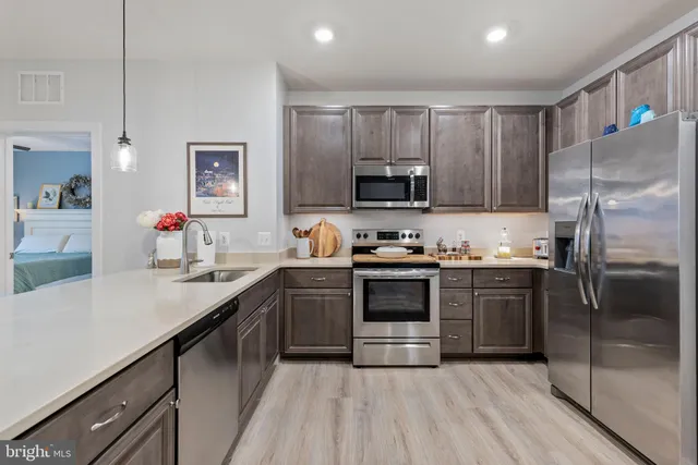 a kitchen with kitchen island granite countertop stainless steel appliances and wooden cabinets