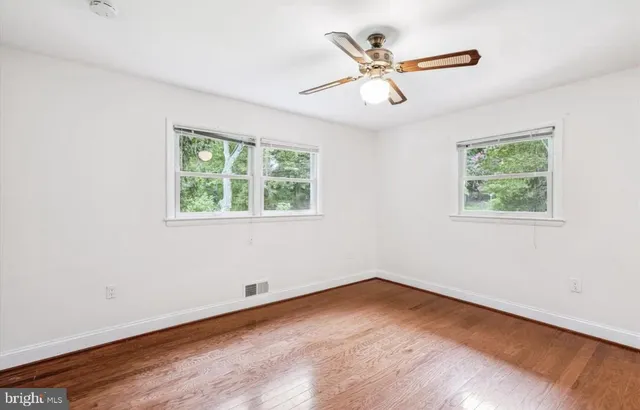 a view of a room with wooden floor and ceiling fan