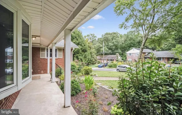 a view of a house with a small yard plants and large tree