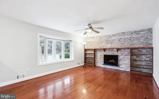 an empty room with windows fireplace and sink