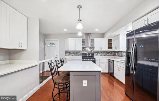 a kitchen with a center island appliances and cabinets