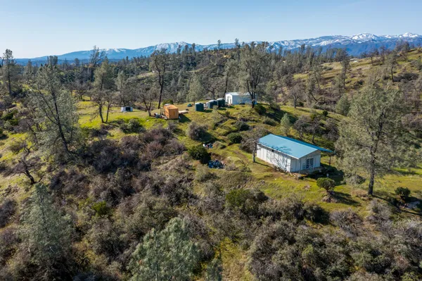 a view of a house with a mountain and a forest