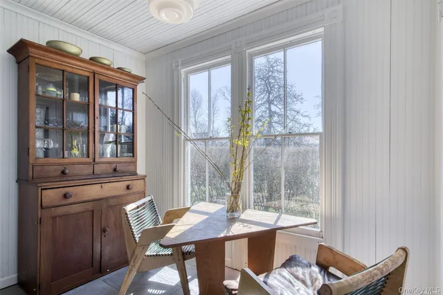 a view of a dining room with furniture large windows and wooden floor