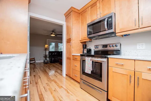 a kitchen with stainless steel appliances granite countertop a refrigerator a stove and a microwave oven with cabinets