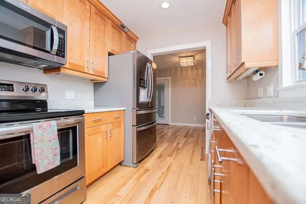 a kitchen with granite countertop a stove a sink and a microwave