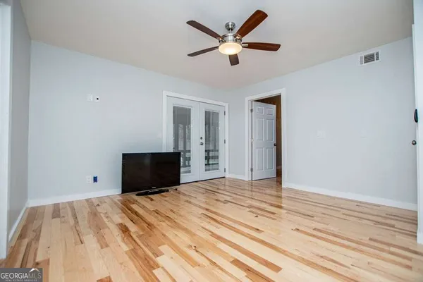 a view of a hallway with wooden floor and staircase