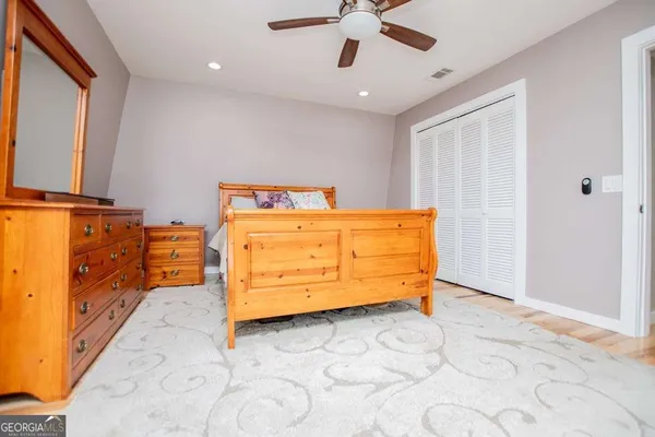 a view of a hallway with wooden floor and closet area