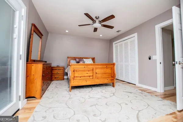 a view of a room with wooden floor and a ceiling fan