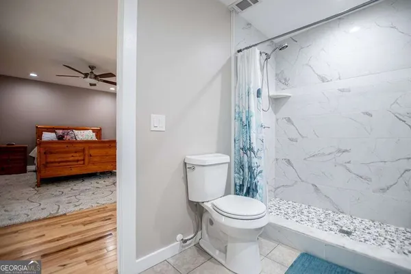an empty room with wooden floor cabinet and windows