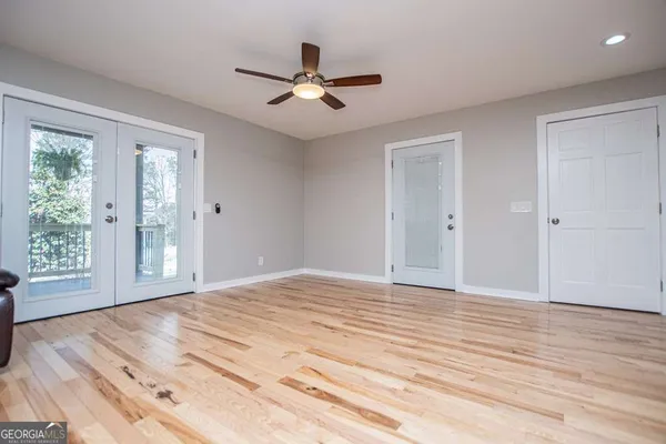 a room with lots of wooden furniture and a chandelier fan