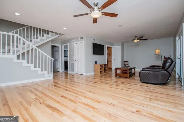 a living room with furniture and a wooden floor