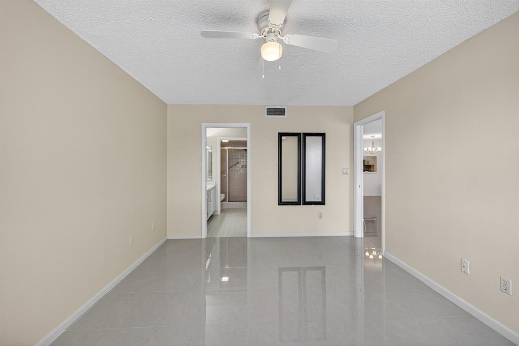 7214 South Devon Drive, Unit 7214 Tamarac, FL 33321 - Photo 12 of 24 an empty room with windows and fan