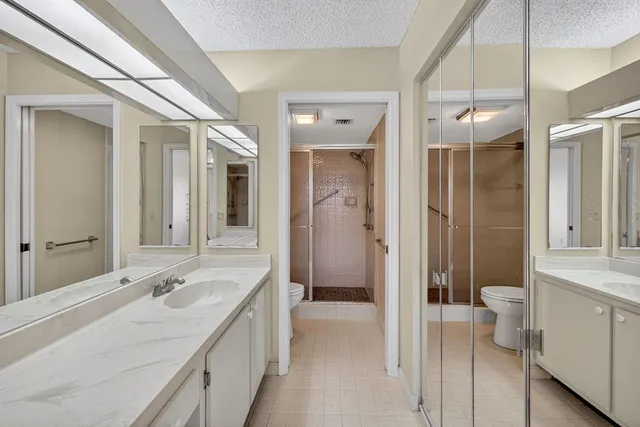 a spacious bathroom with a shower a sink and a mirror