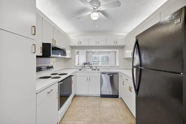 a kitchen with white cabinets and stainless steel appliances