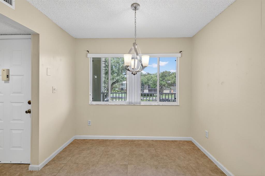 7214 South Devon Drive, Unit 7214 Tamarac, FL 33321 - Photo 4 of 24 a view of an empty room with windows and chandelier