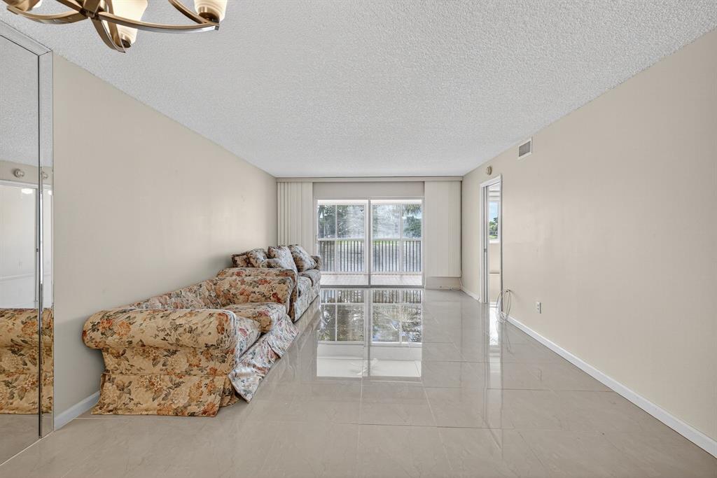 7214 South Devon Drive, Unit 7214 Tamarac, FL 33321 - Photo 5 of 24 a bed sitting in a bedroom next to a window