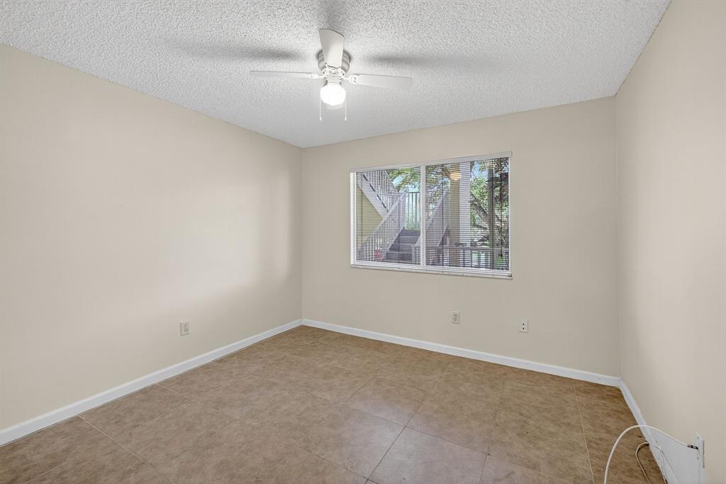 7214 South Devon Drive, Unit 7214 Tamarac, FL 33321 - Photo 7 of 24 an empty room with windows and fan