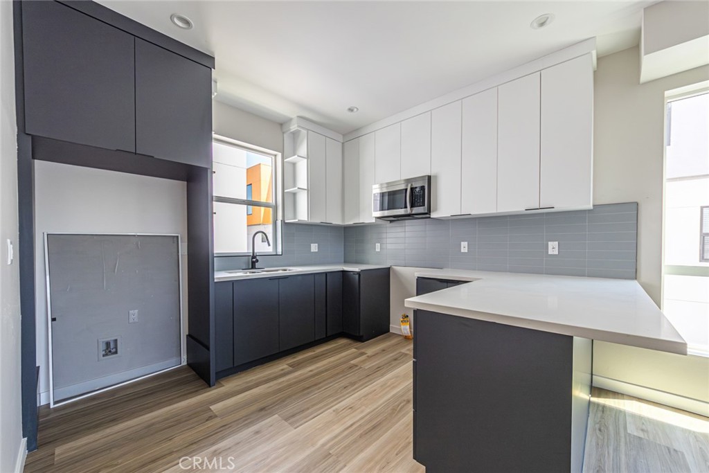6700 Balboa Boulevard, Unit 1 Van Nuys, CA 91406 - Photo 11 of 54 a kitchen with kitchen island granite countertop a sink stainless steel appliances and cabinets