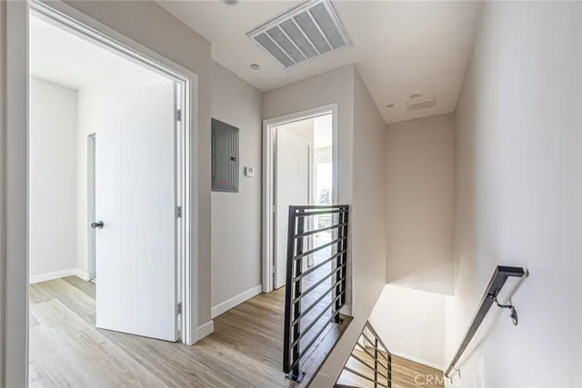 a view of a hallway with wooden floor and staircase