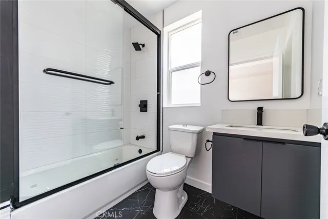 a bathroom with a toilet sink vanity tub and shower