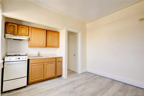 a view of a kitchen with wooden floor and electronic appliances